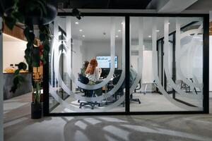 A diverse group of businessmen collaborates and tests a new virtual reality technology, wearing virtual glasses, showcasing innovation and creativity in their futuristic workspace photo