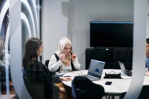 A diverse group of businessmen collaborates and tests a new virtual reality technology, wearing virtual glasses, showcasing innovation and creativity in their futuristic workspace photo