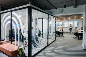 A diverse group of businessmen collaborates and tests a new virtual reality technology, wearing virtual glasses, showcasing innovation and creativity in their futuristic workspace photo