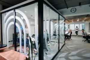 A diverse group of businessmen collaborates and tests a new virtual reality technology, wearing virtual glasses, showcasing innovation and creativity in their futuristic workspace photo