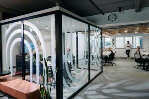 A diverse group of businessmen collaborates and tests a new virtual reality technology, wearing virtual glasses, showcasing innovation and creativity in their futuristic workspace photo