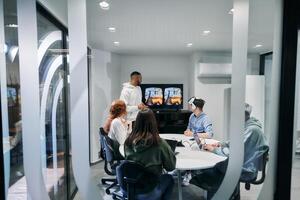 A diverse group of businessmen collaborates and tests a new virtual reality technology, wearing virtual glasses, showcasing innovation and creativity in their futuristic workspace photo