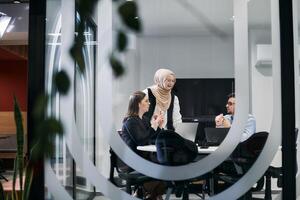 A diverse group of businessmen collaborates and tests a new virtual reality technology, wearing virtual glasses, showcasing innovation and creativity in their futuristic workspace photo