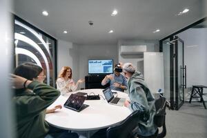 A diverse group of businessmen collaborates and tests a new virtual reality technology, wearing virtual glasses, showcasing innovation and creativity in their futuristic workspace photo