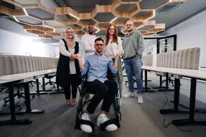 Young businessmen in a modern office extend a handshake to their business colleague in a wheelchair, showcasing inclusivity, support, and unity in the corporate environment. photo