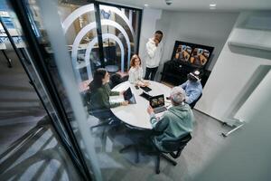 A diverse group of businessmen collaborates and tests a new virtual reality technology, wearing virtual glasses, showcasing innovation and creativity in their futuristic workspace photo
