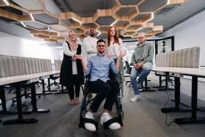 Young businessmen in a modern office extend a handshake to their business colleague in a wheelchair, showcasing inclusivity, support, and unity in the corporate environment. photo