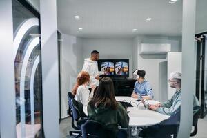 A diverse group of businessmen collaborates and tests a new virtual reality technology, wearing virtual glasses, showcasing innovation and creativity in their futuristic workspace photo