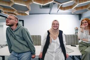 A group of young business professionals stands together, taking a well deserved break from their busy workday, showcasing camaraderie, teamwork, and a moment of relaxation in their dynamic workplace photo
