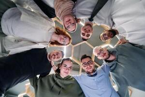 In a modern office, a group of young business professionals is captured in a warm and embracing hug, reflecting the spirit of unity, collaboration, and shared success in their dynamic workplace. photo