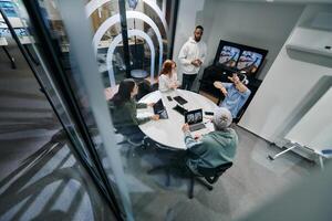 A diverse group of businessmen collaborates and tests a new virtual reality technology, wearing virtual glasses, showcasing innovation and creativity in their futuristic workspace photo