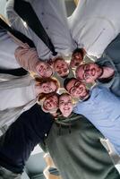 In a modern office, a group of young business professionals is captured in a warm and embracing hug, reflecting the spirit of unity, collaboration, and shared success in their dynamic workplace. photo