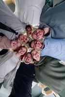 In a modern office, a group of young business professionals is captured in a warm and embracing hug, reflecting the spirit of unity, collaboration, and shared success in their dynamic workplace. photo