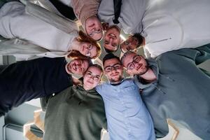 In a modern office, a group of young business professionals is captured in a warm and embracing hug, reflecting the spirit of unity, collaboration, and shared success in their dynamic workplace. photo