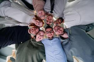 In a modern office, a group of young business professionals is captured in a warm and embracing hug, reflecting the spirit of unity, collaboration, and shared success in their dynamic workplace. photo