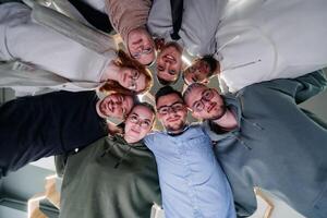 In a modern office, a group of young business professionals is captured in a warm and embracing hug, reflecting the spirit of unity, collaboration, and shared success in their dynamic workplace. photo