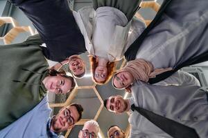 In a modern office, a group of young business professionals is captured in a warm and embracing hug, reflecting the spirit of unity, collaboration, and shared success in their dynamic workplace. photo