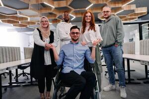 Young businessmen in a modern office extend a handshake to their business colleague in a wheelchair, showcasing inclusivity, support, and unity in the corporate environment. photo