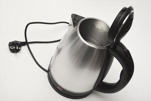 A metal teapot with a black handle. photo