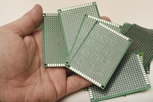 green breadboard for electronics. The printed circuit board is in your hand. photo