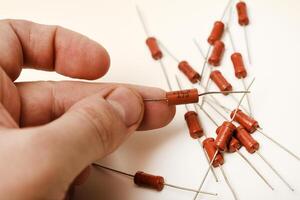 Old film resistors in your hand. Resistors with axial terminals. photo