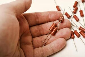 Old film resistors in your hand. Resistors with axial terminals. Elements of electronics. photo