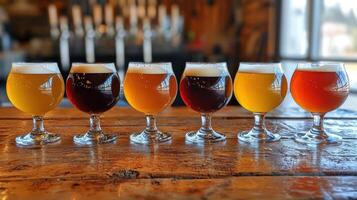 A row of beer glasses lined up on a wooden table photo