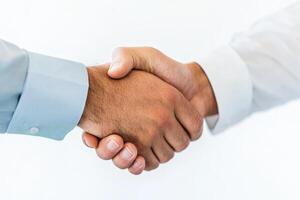 Two individuals engage in a firm handshake to signify agreement in a professional setting photo
