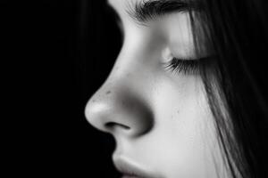Close-up of a young person's serene profile highlighting facial features against a dark background photo