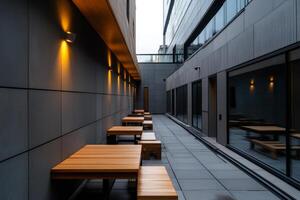 Modern outdoor seating area with wooden tables and ambient lighting in an urban setting during twilight photo