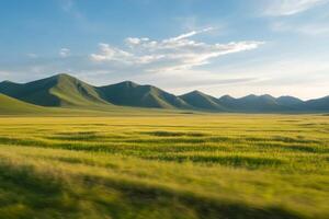 Expansive green fields and rolling hills under a clear blue sky at sunset photo