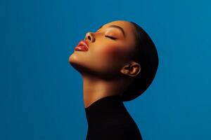 Elegant portrait of a woman with smooth skin and bright lips against a vibrant blue background photo