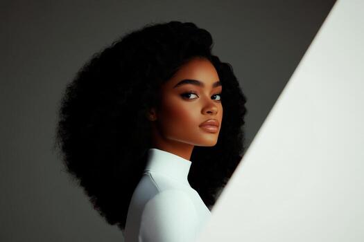 Elegant portrait of a woman with natural curls posing against a minimalistic background in soft lighting photo