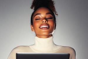 Happy woman enjoying digital content while using a laptop in a cozy indoor setting at night photo