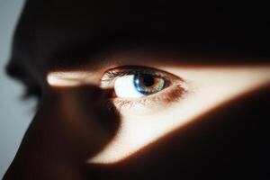 Close-up of a person's eye showcasing unique color and shadows highlighting facial features in soft light photo