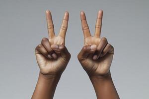 Hands making peace sign gesture representing unity and positivity during contemporary cultural movements photo