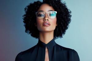 Model with curly hair poses confidently wearing glasses against a soft gradient background in a studio setting photo