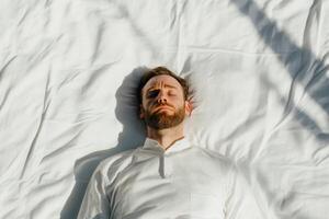 Man resting with eyes closed on a white in a bright and serene environment during daytime photo