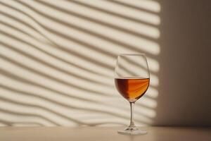 Elegant wine glass casting shadows in warm light, highlighting intricate patterns against a wall photo