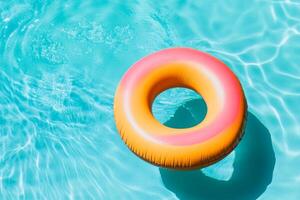Colorful inflatable pool float resting in clear blue water on a sunny day photo