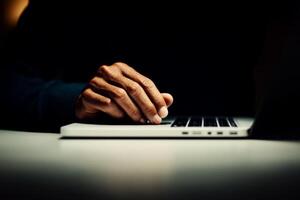 Hands typing on a laptop in low light, creating a focused atmosphere for work or research tasks photo