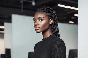 Confident young woman with braids poses in a modern office space during daylight hours photo
