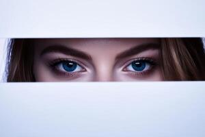 Captivating blue eyes peek through a narrow opening in a white background photo