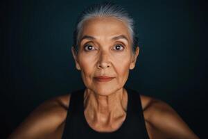 Portrait of an elderly woman with gray hair expressing calm confidence against a dark background photo
