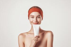 Smiling woman holding skincare product against a neutral background in a beauty routine setting photo