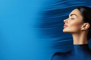 Woman with serene expression against a vibrant blue background showcasing movement and tranquility in a modern setting photo