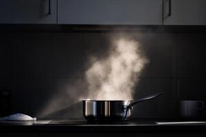 Steam rises from a pot on the stove in a modern kitchen during evening cooking photo