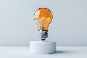 Light bulb floating above a minimalist pedestal with an orange hue photo