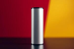 Metal cylindrical object placed on a dark surface with contrasting red and yellow backgrounds photo