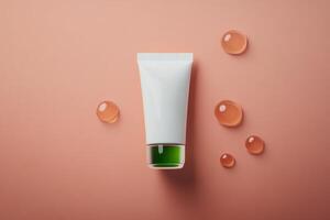 Beauty cream tube and gel drops arranged on soft pink background for skincare design photo